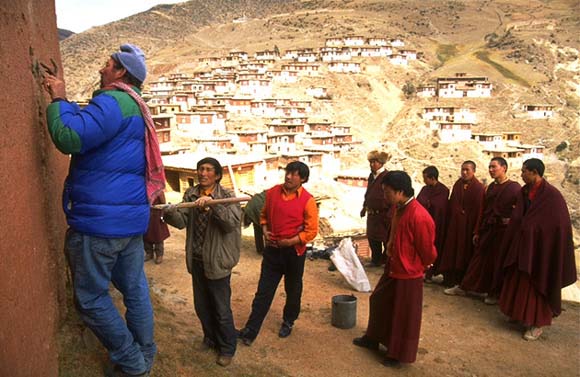 John Sanday, assisted by Tibetan workers, places tell-tales in the exterior wall of Palpung to monitor movement of a crack.
