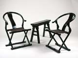a pair of black lacquer folding horseshoe-backed armchairs