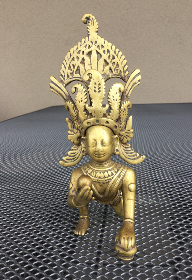 A brass figure of Gopi Krishna with his tiara